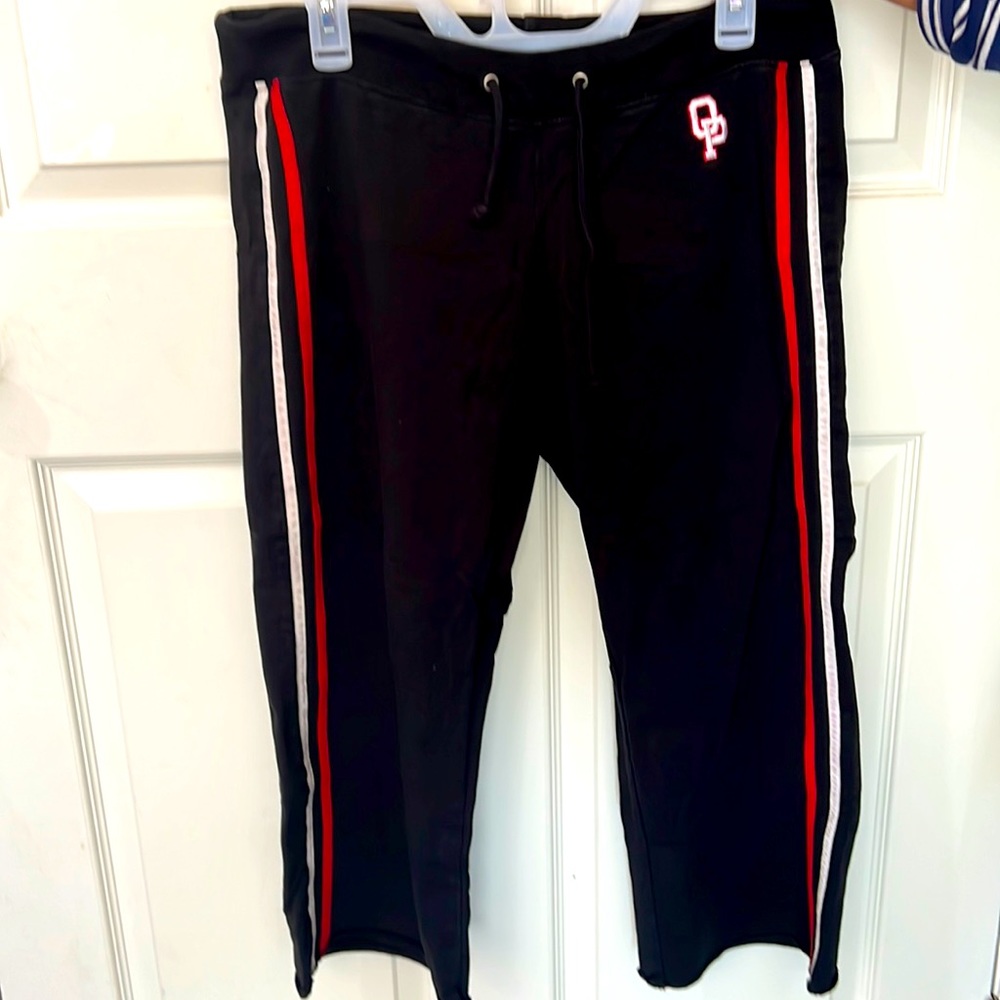 Black jogger pants with red and white stripes down the side with the symbol OP